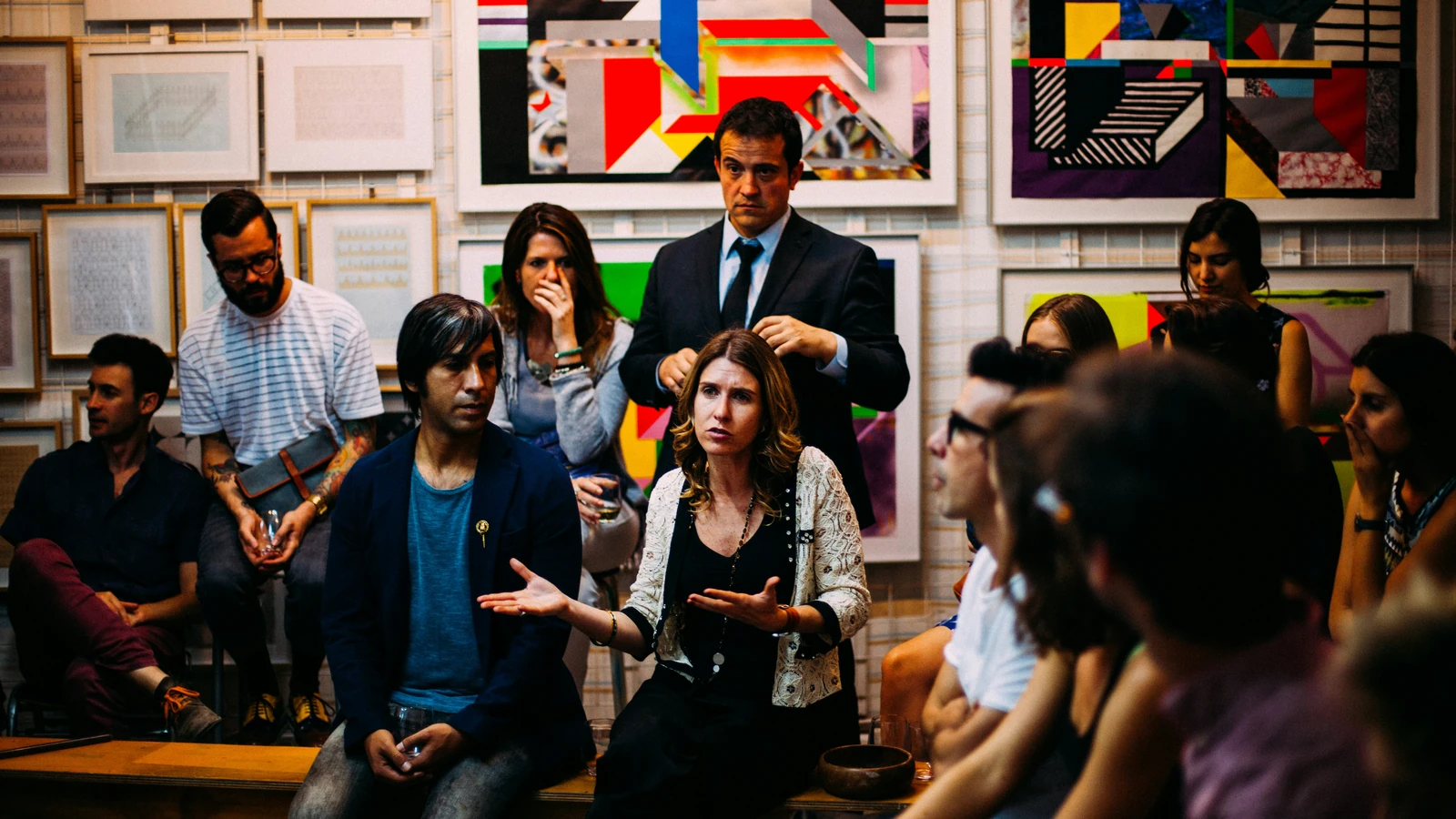 Equipo creativo dialogando sobre una estrategia de mercadotecnia frente a obras gráficas
